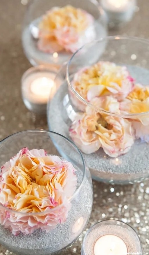استفاده از ماسه و شن برای تزیین ظرف شیشه ای تنگی با گل مصنوعی
