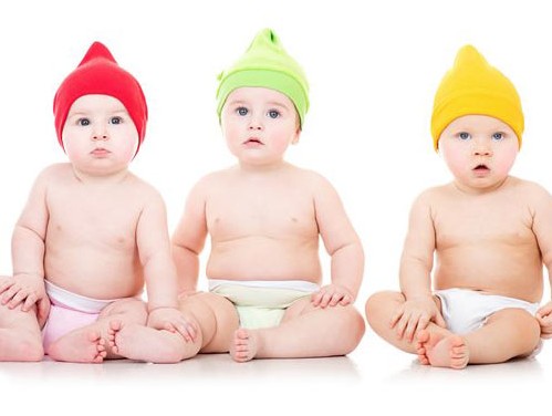 عکس با کیفیت از سه نوزاد با کلاه های رنگی