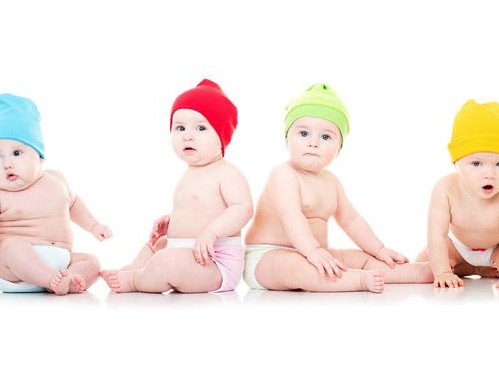 عکس با کیفیت از چهار نوزاد با کلاه های رنگی