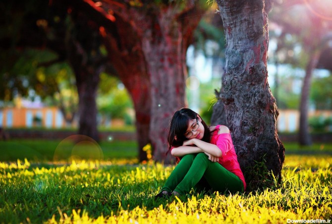 عکس زمینه دختر نشسته در کنار درخت پس زمینه | والپیپر گرام