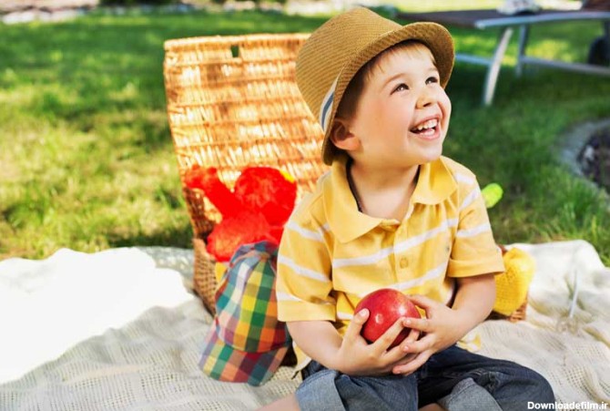 دانلود تصویر با کیفیت پسر شاد سیب به دست در فضای باز