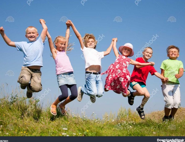 گروه کودکان شاد پریدن از روی سبزه زار تابستان در برابر آسمان آبی ...