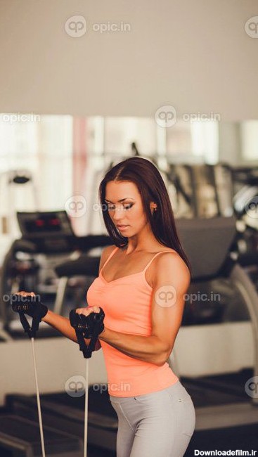 دانلود عکس زن جوان زیبا در حال انجام ورزش در باشگاه بدنسازی ...