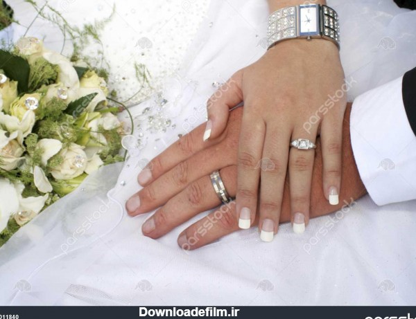 محبت زن و شوهر دست در دست با حلقه در برابر لباس عروسی 1011840