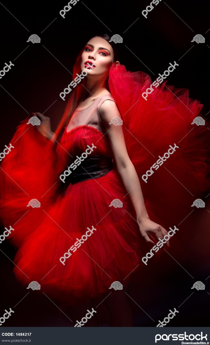 زن جوان شیک و زیبا با لباس قرمز بیش از پس زمینه سیاه نور مخلوط 1484217