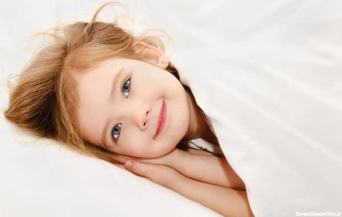 دانلود تصویر با کیفیت لبخند دختر بچه چشم آبی در حال خواب