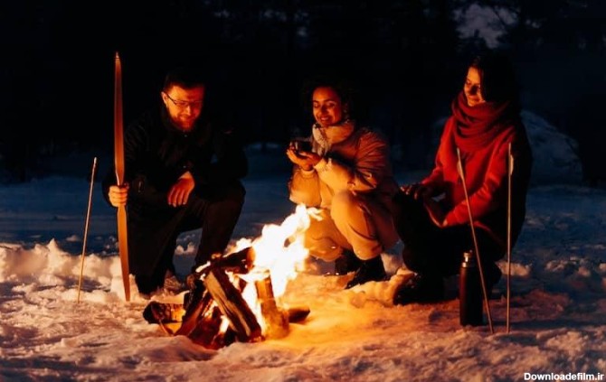 خانواده ای در کنار آتش در شبی برفی