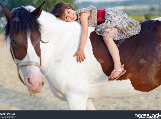 دختر کوچولو با لباسی که سوار بر اسب سفیدش می تازد 1092336