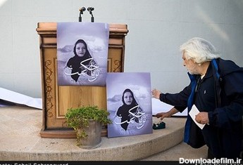 کامران ملکی عضو هیات مدیره خانه سینما عکسی از زنده‌یاد ثریا حکمت را در جایگاه سخنرانی قرار می‌دهد.