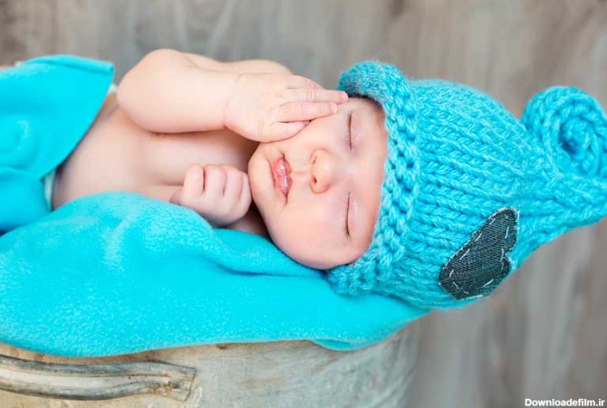 دانلود تصویر باکیفیت نوزاد خوابیده با پتو و کلاه آبی