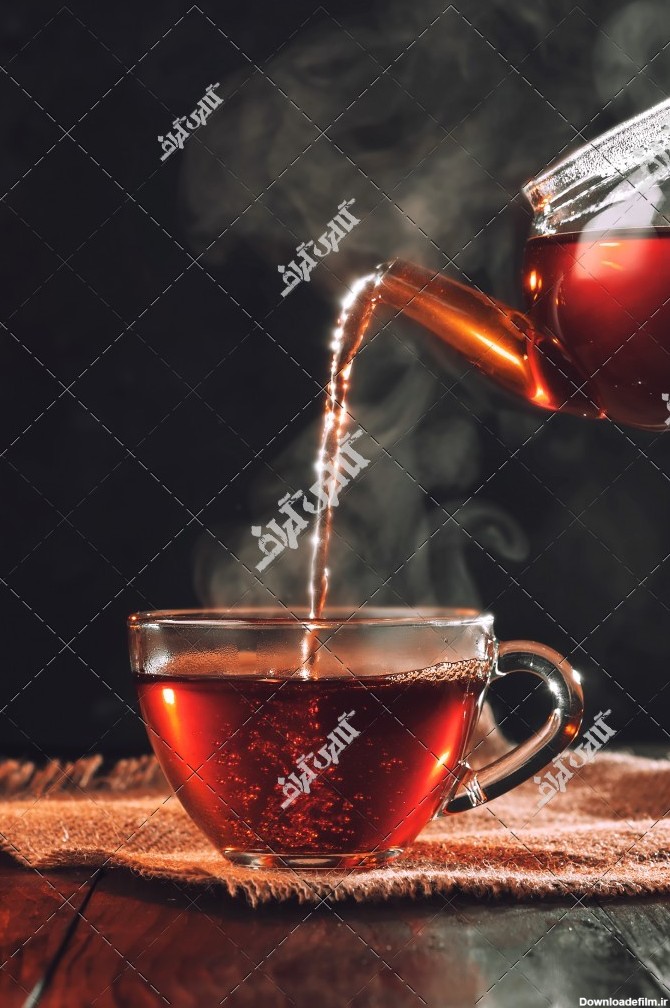 عکس قوری چای در حال ریختن چای داخل استکان