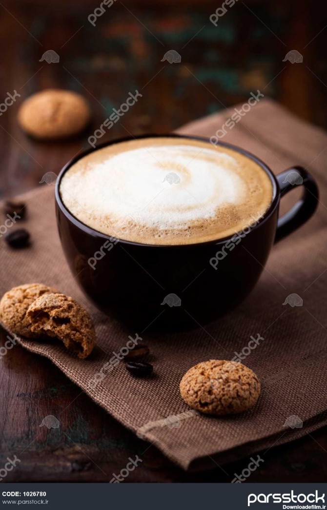 جام کافه لکه های شیر قهوه طلا و biscotti روی میز 1026780