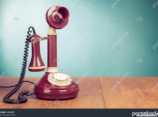 تلفن ثابت قدیمی روی میز چوبی در نزدیکی دیوار آکومراین 1411477