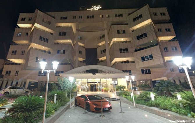 عکس هتل ایران در طول شب با خودرویی لوکس در ورودی هتل
