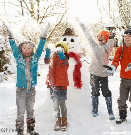 عکس خانواده چهار نفره در حال برف بازی در کنار آدم برفی
