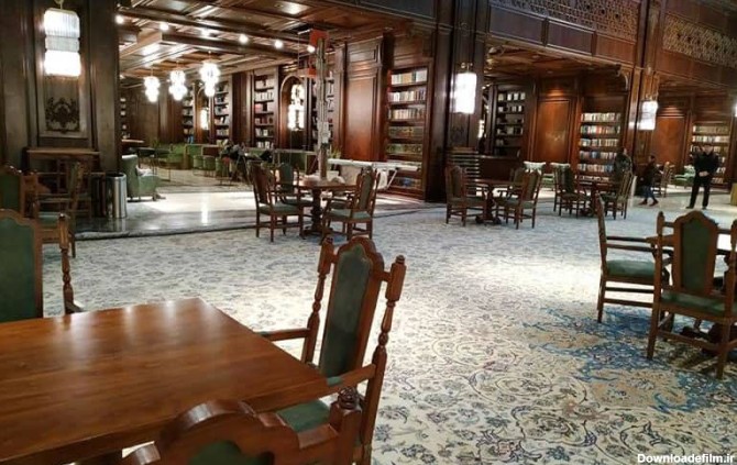 میز و صندلی های چوبی در کتابخانه ای بزرگ