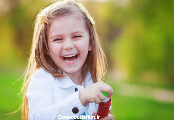 دانلود تصویر با کیفیت دختر بچه در حال خندیدن در فضای باز