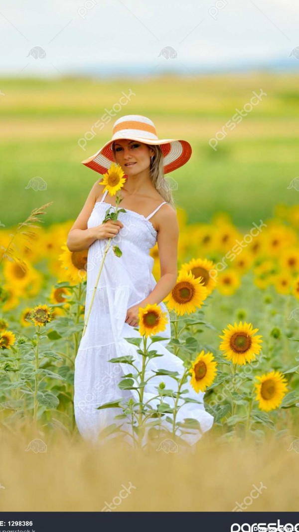 زن جوان در گل آفتابگردان زمینه در تابستان 1298386