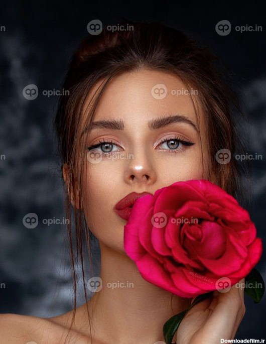 دانلود عکس مدل زیبا در دست گرفتن یک گل رز قرمز بزرگ در پس زمینه ...