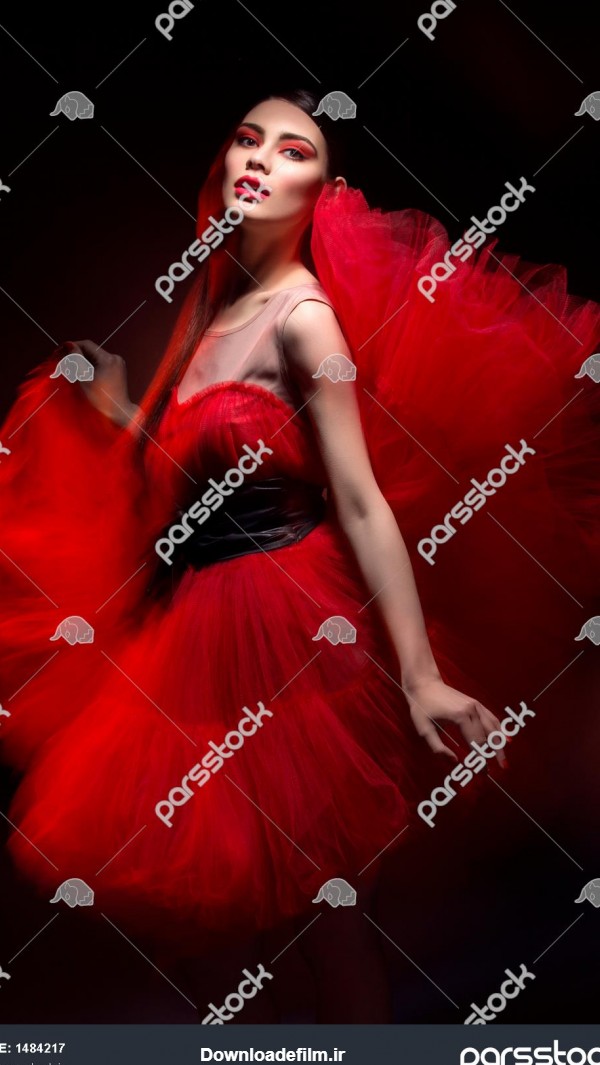 زن جوان شیک و زیبا با لباس قرمز بیش از پس زمینه سیاه نور مخلوط 1484217