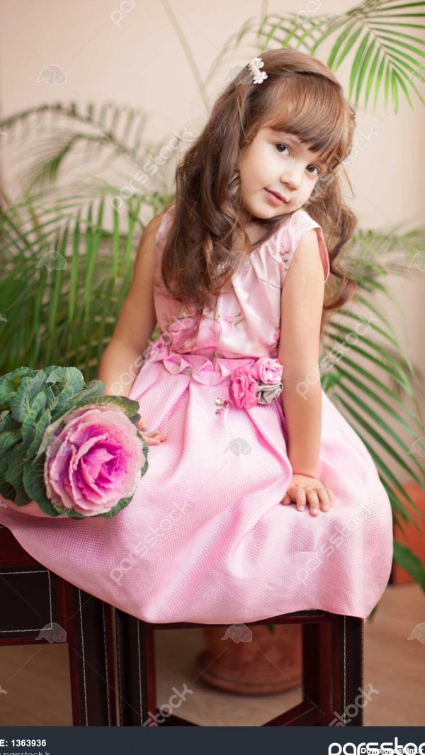 مدل زیبا دختر بچه مشاهده در لوکس صورتی لباس و گل در خانه نما در ...