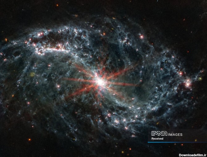 شبکه‌های پیچیده‌ای از گاز و غبار که در کهکشان مارپیچی تار مانند NGC 7496 در یک تصویر ترکیبی که توسط تلسکوپ جیمز وب گرفته شده و توسط ناسا در 16 فوریه 2023 منتشر شد، دیده می‌شود. هشت سنبله پراش قرمز از هسته بسیار درخشان آن خارج شده‌اند. نقاط رنگارنگ در پس زمینه نشان دهنده کهکشان های پس زمینه است.