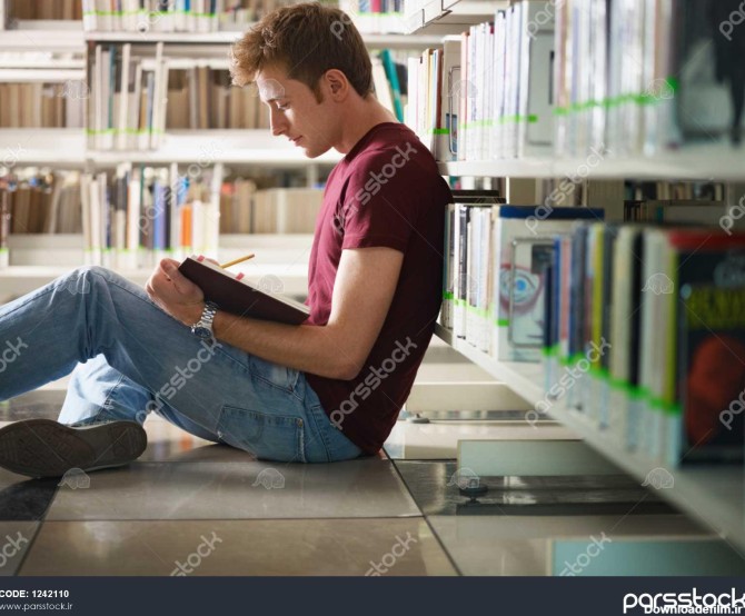 مرد دانشجو نشسته روی زمین در کتابخانه خواندن کتاب شکل افقی مشاهده ...