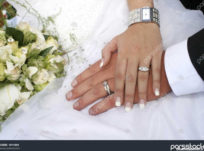 محبت زن و شوهر دست در دست با حلقه در برابر لباس عروسی 1011840