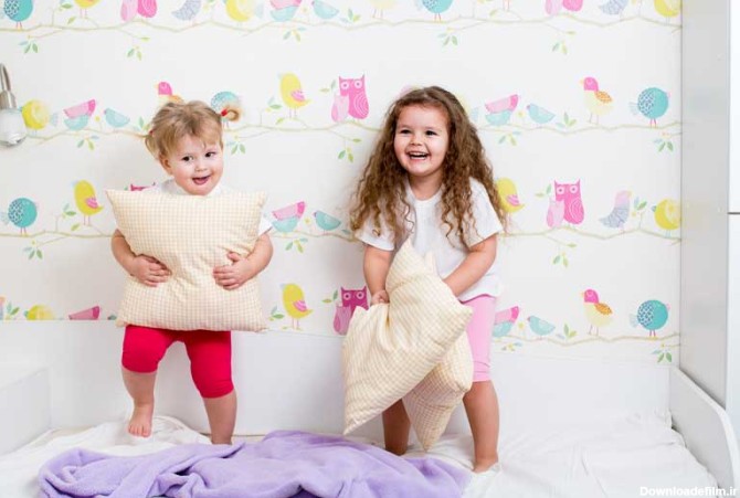 دانلود تصویر با کیفیت دو کودک در حال بازی در تختخواب